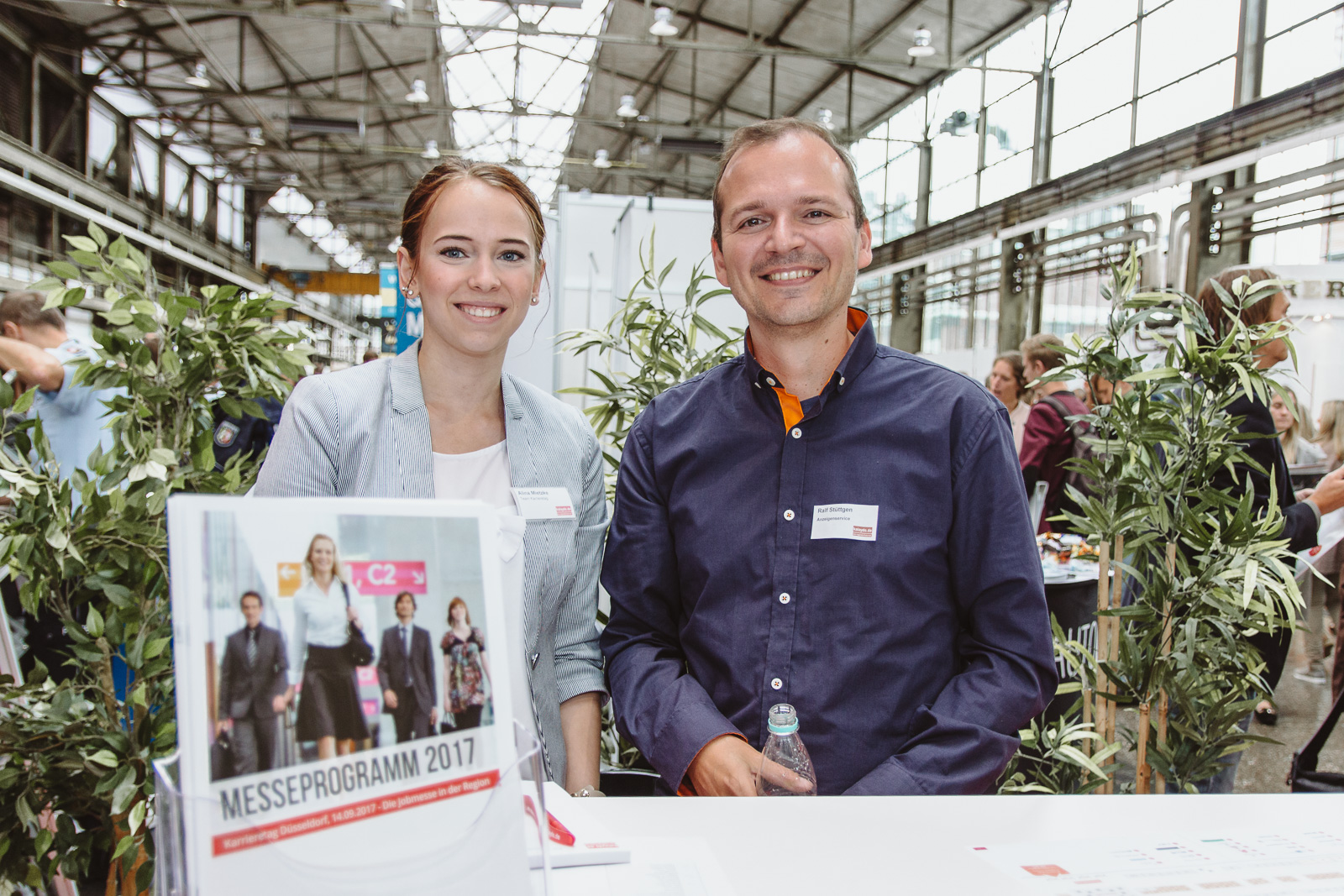 natürliche Reportagefotografie auf Messe - Teamfoto am Infoschalter